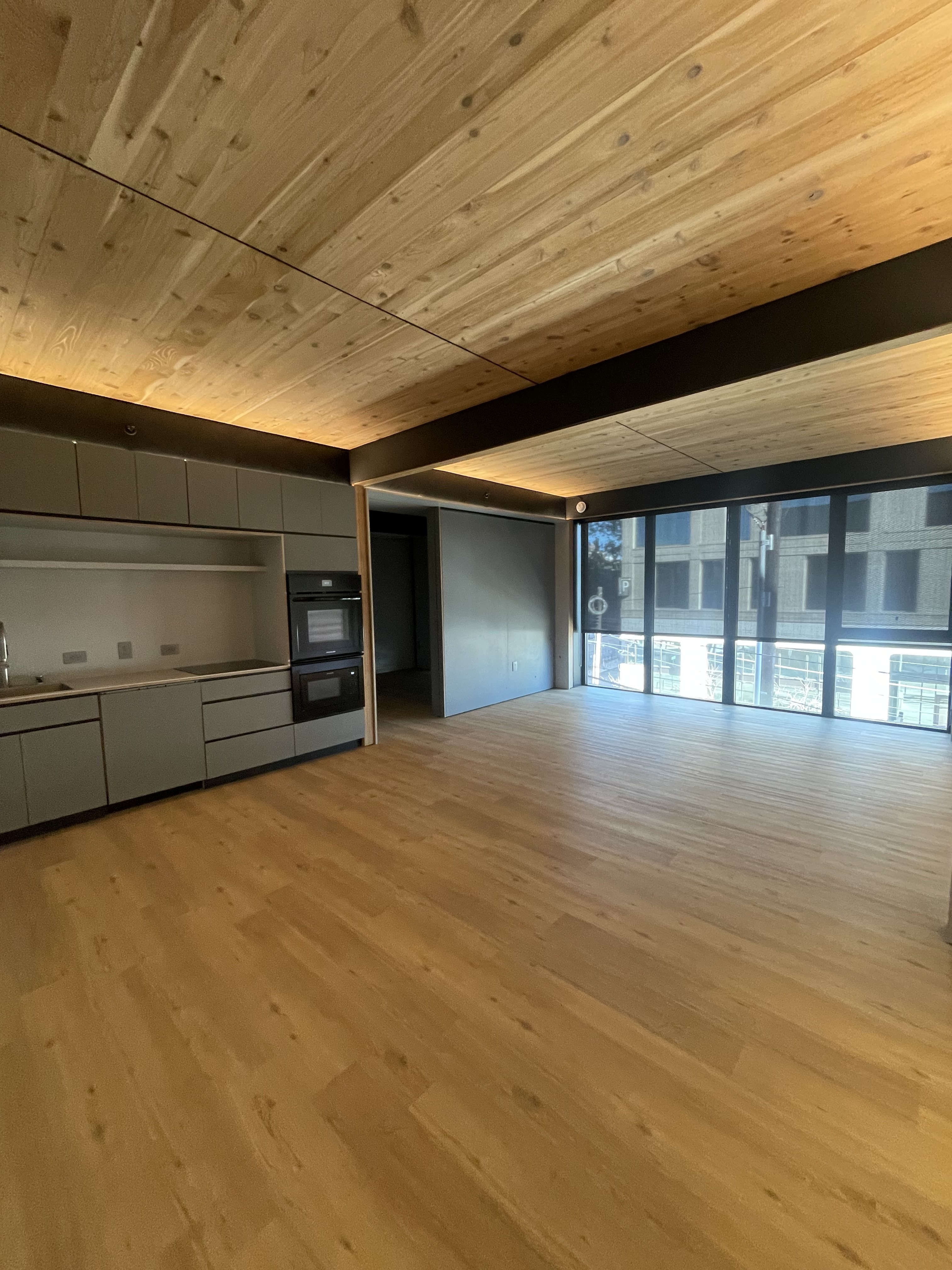 Bright open-plan living room with kitchen in the background