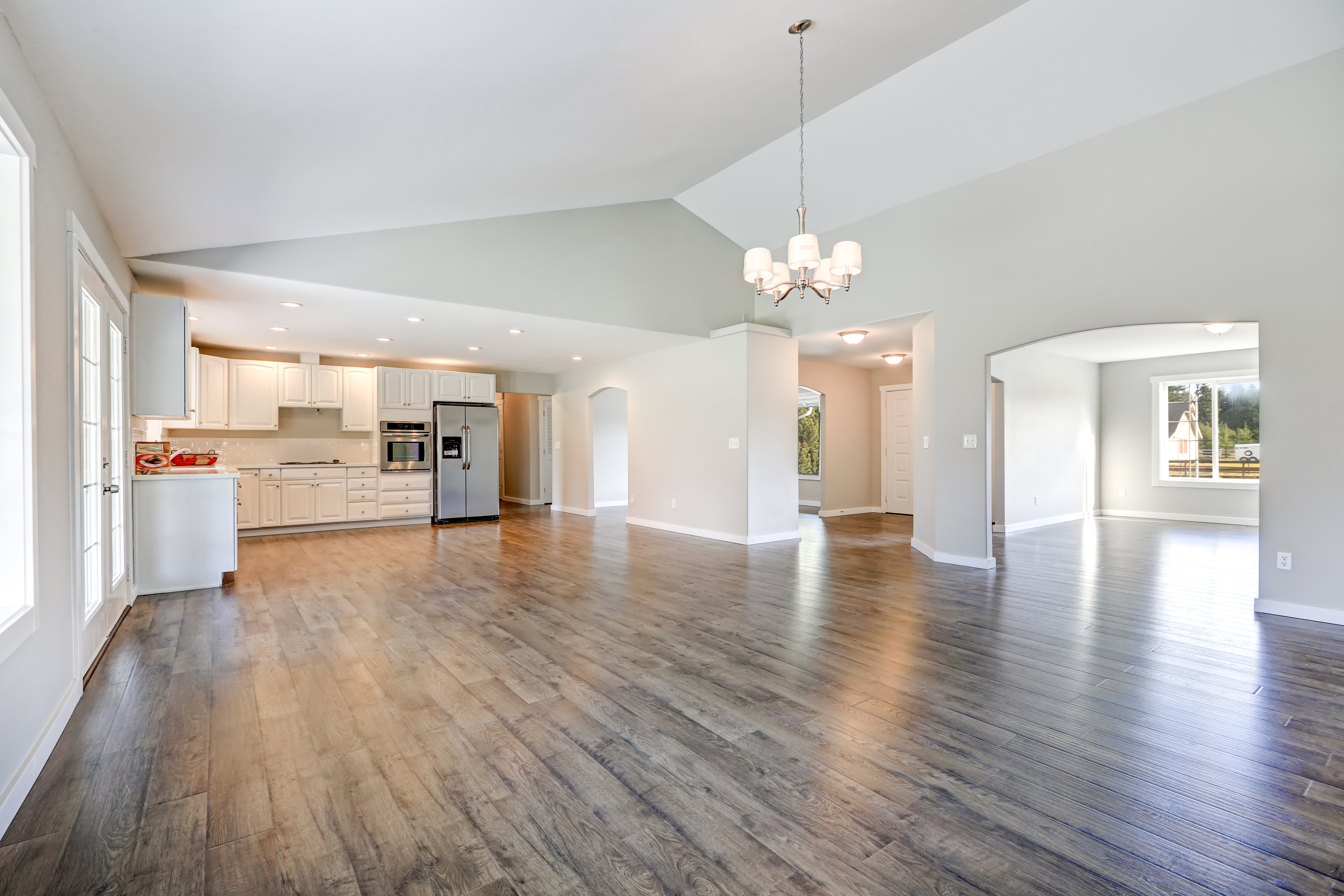 An empty living room with two areas marked out for living and dining.